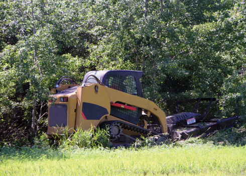 cat skid steer pulling forestry mulching mower